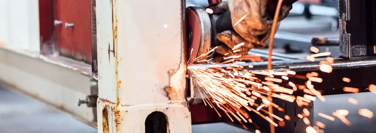 Eine Hand, die an einem Container schweißt. Die Funken fliegen. 