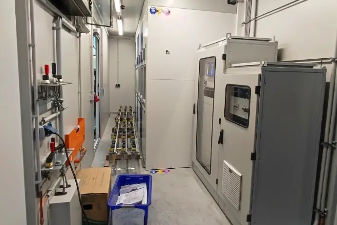 Die Innenansicht eines Containers als Mittelspannungsanlage der CHS Container Group. Es stehen verschiedene Gerätschaften im Container.