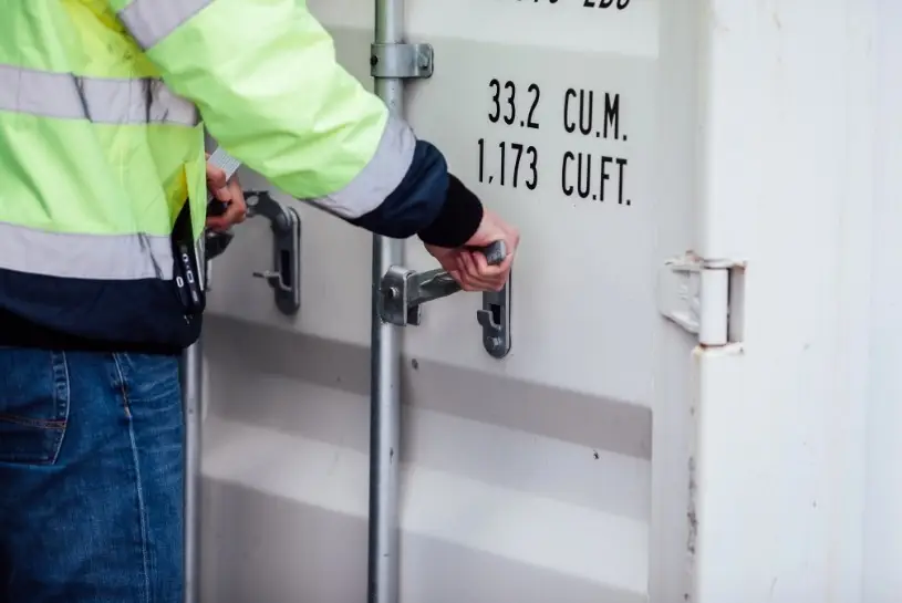 Eine Person, die einen weißen Container öffnet. Der Fokus liegt auf den Händen.