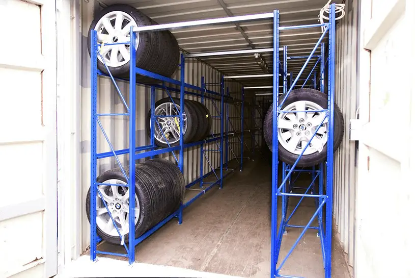 Reifencontainer der CHS Container Group, Innenansicht bei der man Regale sieht und mehrere Reifen, die darin gelagert sind.