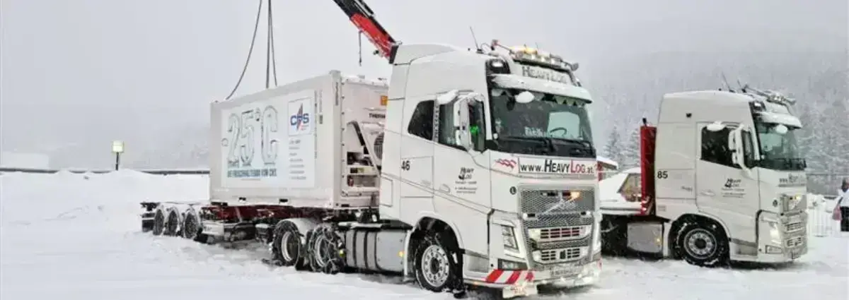 Lieferoptionen Deutschland- und Europaweit Kühlcontainer werden von zwei LKWs mit Kran abgeladen