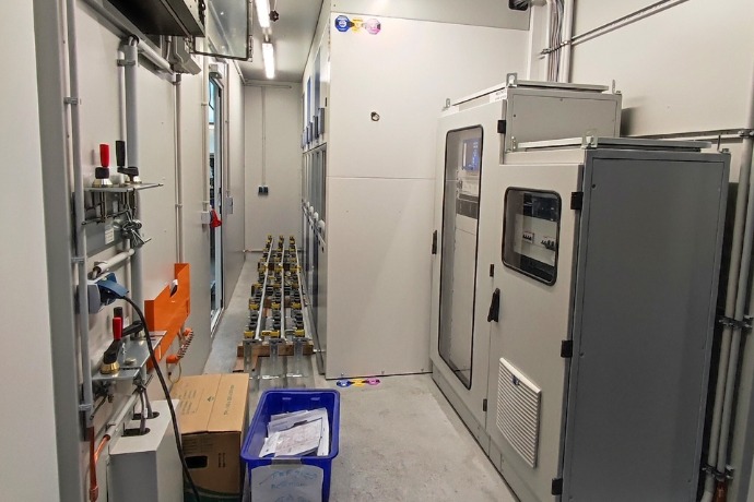 Die Innenansicht eines Containers als Mittelspannungsanlage der CHS Container Group. Es stehen verschiedene Gerätschaften im Container.