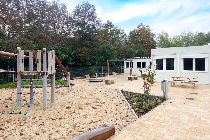 Schule (1) Ein Spielplatz einer Schule der CHS Container Group. Auf der linken Seite sieht man die weißen Container der Anlage.