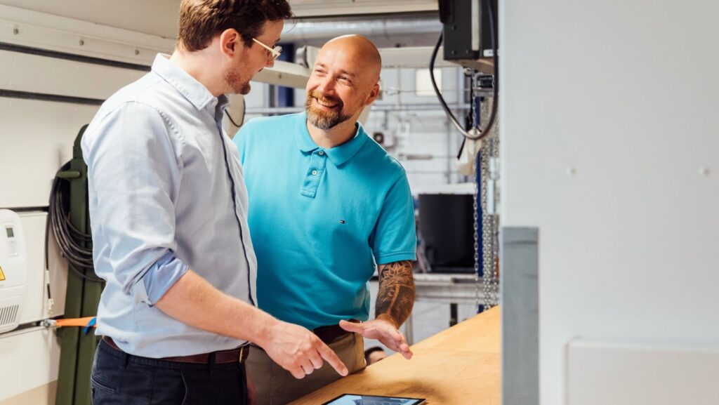 Zwei Personen lächeln sich an. Unterstützung bei der CHS Container Group