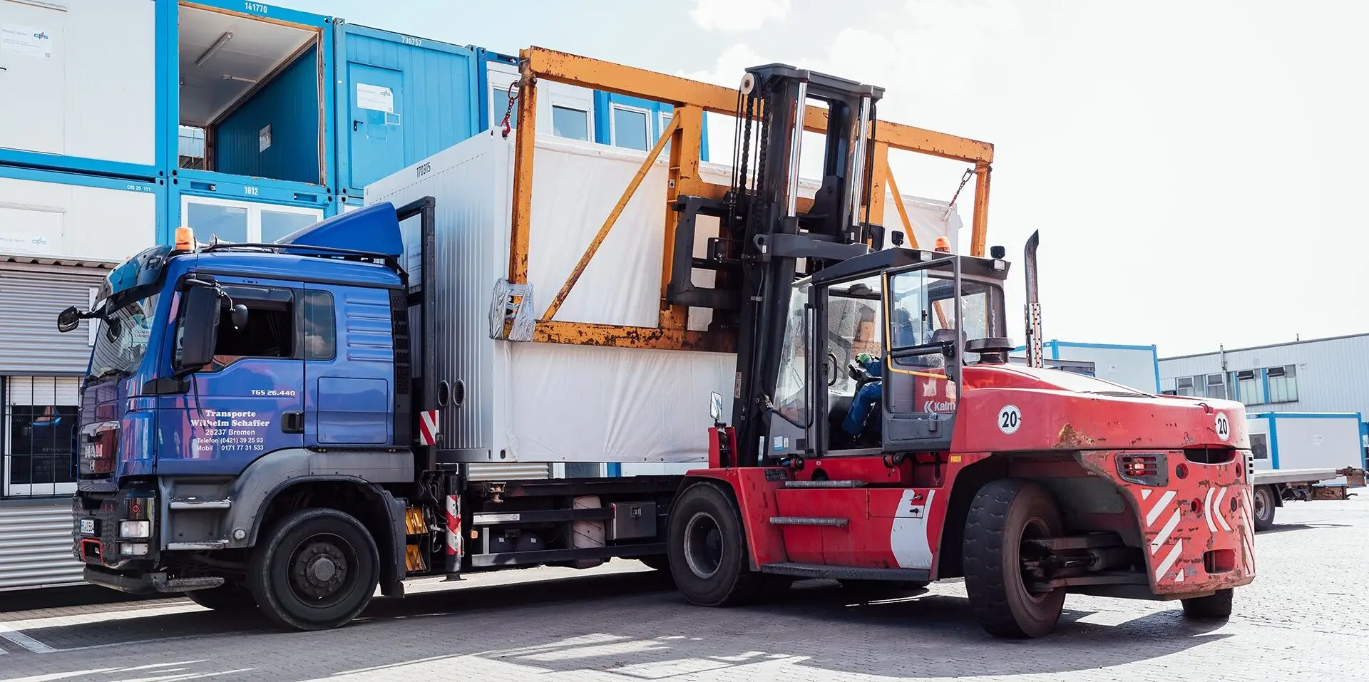 Karriere-bei-CHS-1920px-3 Ein Gabelstapler, der einen Container von einem LKW herunterholt auf dem Containerdepot der CHS Container Group