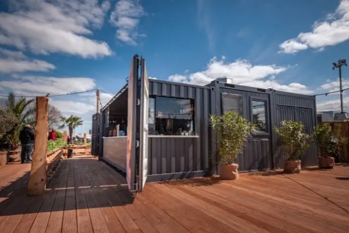 Ein umgebauter Barcontainer bei Lankenauer Höft. Ein Projekt der CHS Container Group. Der Container ist dunkelgrau und lässt sich an der Seite komplett öffnen.