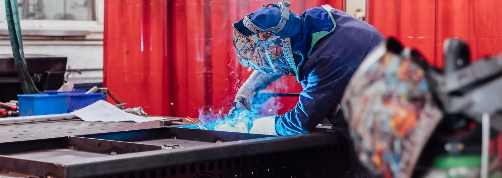 Shipping-Container-Modification A CHS Container Group employee welds metal components for a shipping container modification project.