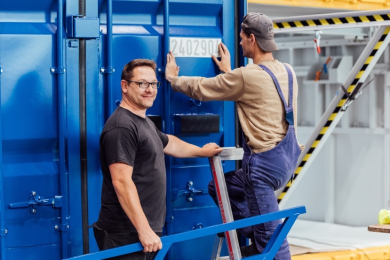 CHS personnel stick an ISO-compliant code onto a freight container.