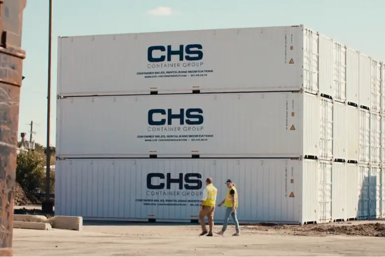 CHS team members walk next to a stack of CHS-branded containers.